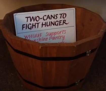 Barrel containing a sign that says two cans to fight hunger