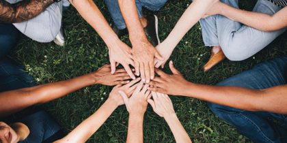 hands of different colors meeting in a circle